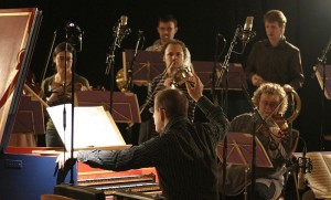 Einer der effizientesten Taktgeber ist (natürlich) der Dirigent: Trevor Pinnock leitet das Europäisch-Brandenburgische Ensemble anlässlich einer Bach-Aufnahme in Sheffield (wie im Hochbarock) vom Cembalo aus, das als Puls- und Harmoniegeber gleichzeitig fungiert (Dezember 2006, Andrew Stepan).